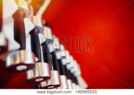Sports equipment dumbbell rests in a row.  hign contrast and monochrome color tone
