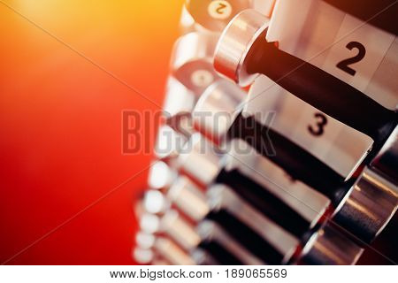 Sports equipment dumbbell rests in a row.  hign contrast and monochrome color tone