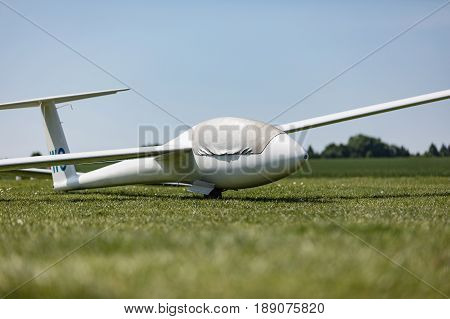 Glider on the grassy airfield in sunny day.