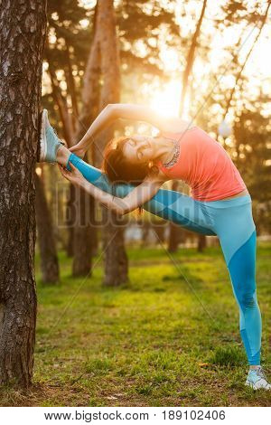 Athlete in sportswear during training in morning at park. Sunflare effect