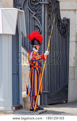 Rome, Italy - May 18, 2017: The Swiss guardsman in parade uniform on the post in front of the Vatican palace in Rome. The Vatican is the most visited place for tourists.
