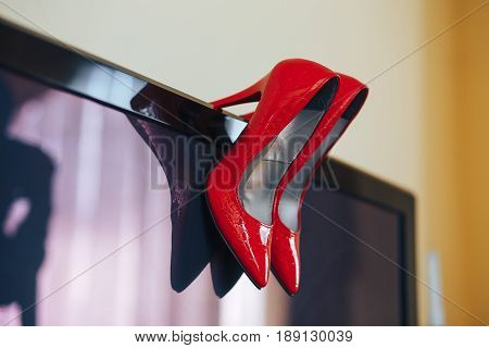 Red beautiful high-heeled wedding shoes made of snake skin