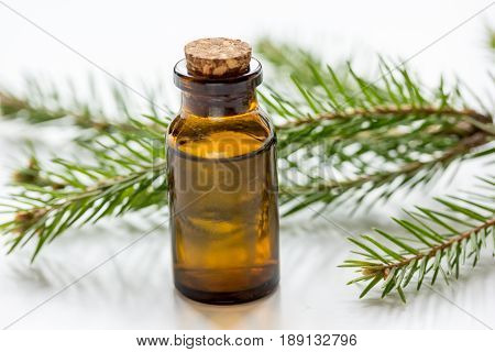 natural fir branches and spruce aroma oil on white table background