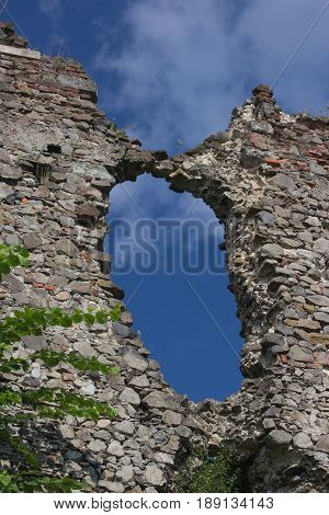 big hole in the wall of destroyed ruined old medieval castle in Khust Ukraine