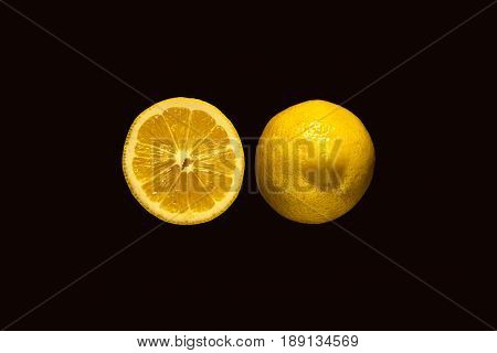 Freshly cut half and whole lemons on rustic boards.