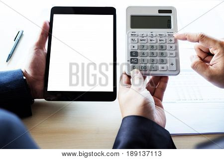 Businessman analysis on calculator new plan financial graph data with business colleagues using digital tablet for estimation at the office invesment concept.