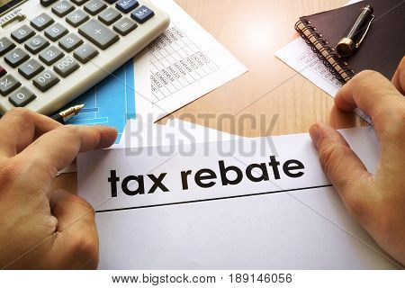 Hands holding documents with title tax rebate.