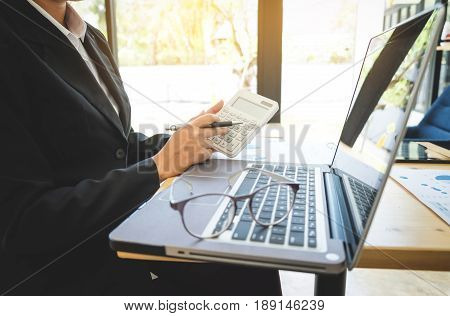 Close-up of accountant Woman using calculator for her work with labtop in office. Tax finance Invoice.