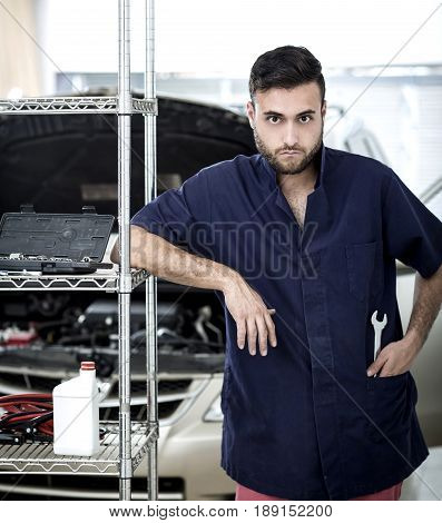 Car Mechanic Man At The Garage Fixing The Engine