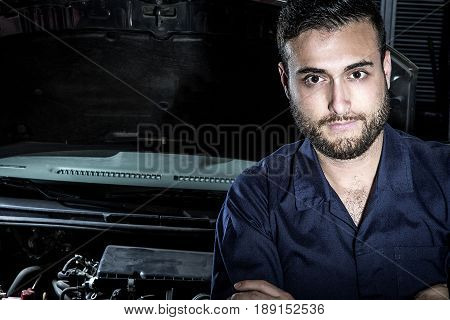 Car mechanic man at the garage fixing the engine