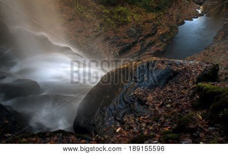 From behind the falls, waters of the Cullasaja River is seen streaming down on the boulders and rocks before flowing on in southern North Carolina