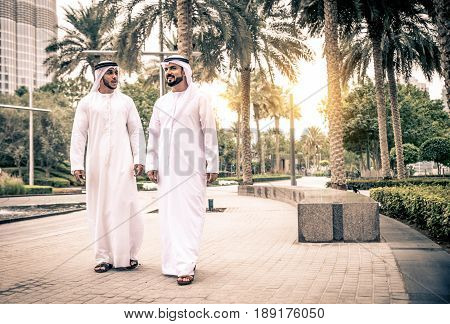 Arabic businessmen walking outdoors in Dubai, UAE