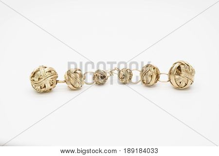 two gold earrings in the form of balls of twisted Golden wire isolated on white background