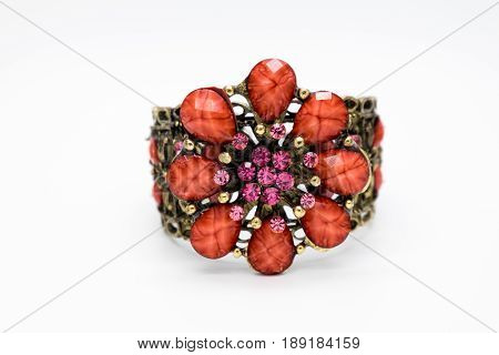 one beautiful bracelet with gold pink and red stones isolated on white background