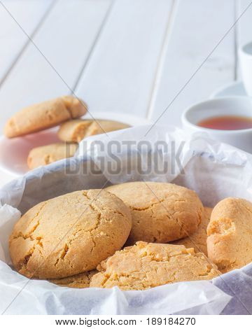 Close Up of Gingernuts in a Tin with Tea in the Background Vertical with Copy Space