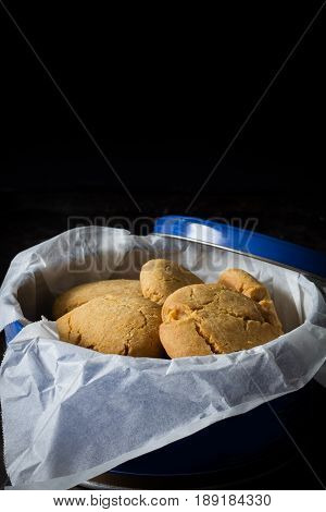 Gingernuts in a Tin on a Dark Background Vertical with Copy Space Above