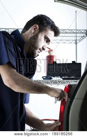Car Mechanic Man At The Garage Fixing The Engine