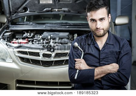 Car Mechanic Man At The Garage Fixing The Engine