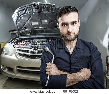Car Mechanic Man At The Garage Fixing The Engine