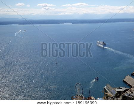 SEATTLE-- JUNE 25: Aerial view of Puget Sound with boats leaving harbor Large Ferris Wheel Wharf and Highway on June 25 2016 in Seattle WA.