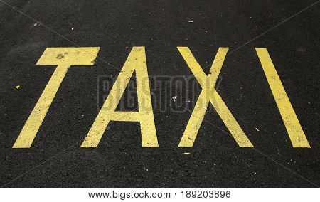 Taxi stop with letters on road vehicle and public transport