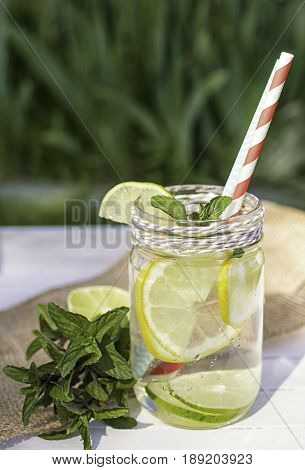Glass jar of home made fresh lemonade wish lemonlime and mint. Summer healpthy concept. Natural light.