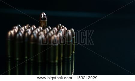Smiling weapon. 9mm bullets on the black mirror background