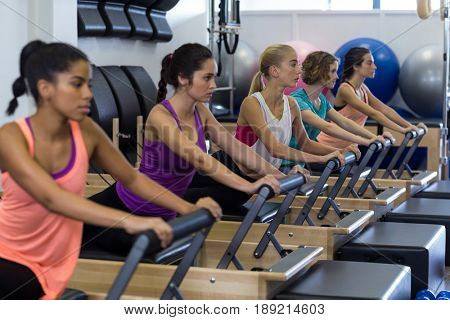 Group of women exercising on reformer in gym