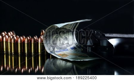 9mm bullets and US 100 dollars on the black mirror background.