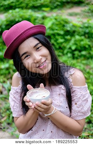 Asian woman relaxing on couch with coffee at water fall cafe.Close up