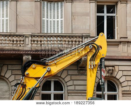 Detail of modern excavator working in city - rebuilding the neighborhood building houses with powerful boom and hydraulic cylinder