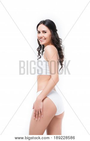 Happy Brunette Woman Posing In White Underwear And Looking At Camera Isolated On White In Studio