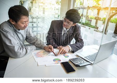 Business team two colleagues discussing new plan financial graph data on office table with laptop business concept.
