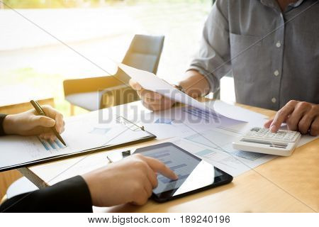 Teamwork process Two business colleague meeting to discussing the business strategy with digital tablet and using calculator. Briefing brainstorming consulting.