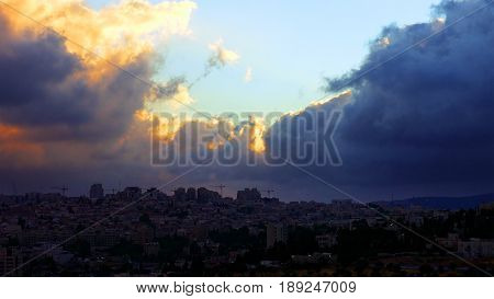 Sunset with huge cumuli clouds over the city. Jerusalem sunset at night dusk.