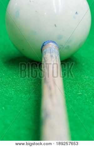 Close up white ball dirty blue chalk powder and cue billiard playing.