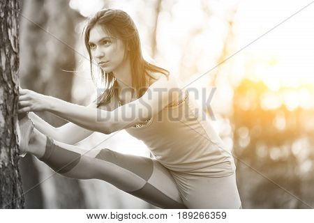 Black and white photo of woman on gymnastics at park in morning. Lensflare effect