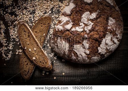 Traditional Whole Grain Rye Bread on Dark Wooden Table Background