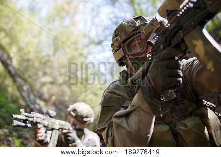 Group of officers on reconnaissance in woods during day