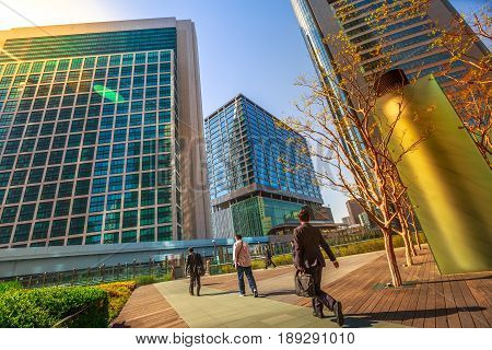 Tokyo, Japan - April 20, 2017: Tokyo urban businessmen commuter walking, Shiodome skyscrapers in Shinbashi Financial District, Minato Ward. Commuter Business District and corporate cityscape concept.