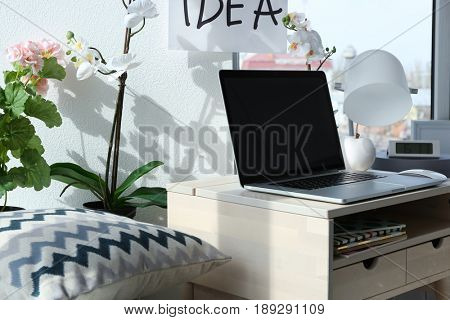 Creative workplace with laptop near windowsill in modern room