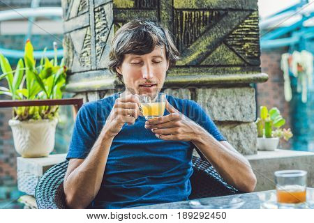 Young Man Sitting In A Cafe Drinking A Delicious Morning Ginger Tea In A Cafe