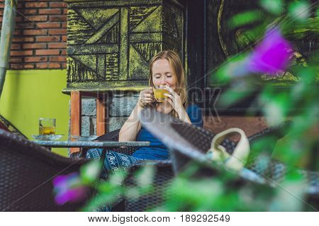 Young Beautiful Redhead Woman Sitting In A Cafe Drinking A Delicious Morning Ginger Tea In A Cafe