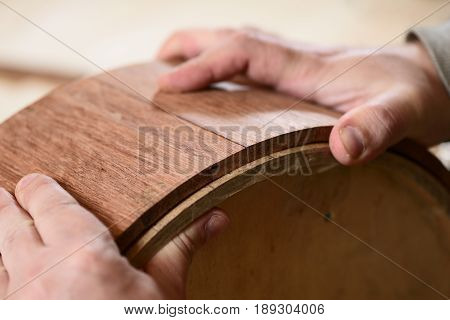Carppenter hands making merbau wood shell for share drum