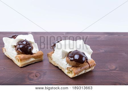 Two Delicious Chocolate And Chantilly French Gateau Cake Tranche Saint Honore On A Natural Ipe Wood