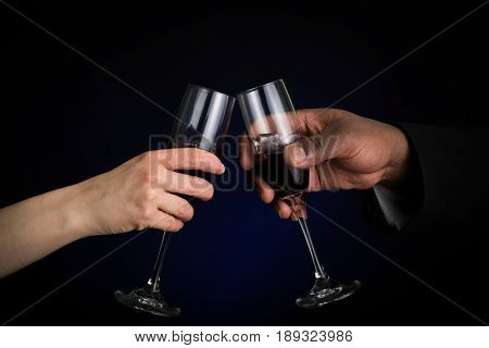 toast by woman and man on a black background with a blue glow