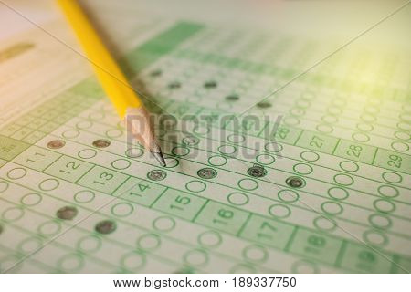 yellow pencil on exam answer sheet education test in universticy concept