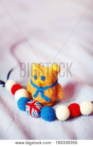 handmade teddy bear and The British flag of fluffy woolen balls is strung like beads on a string