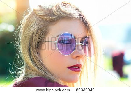 Portrait of beautiful blond girl with transparent purple eyeglasses.