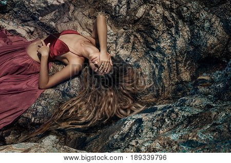 beautiful young woman in red dress laying dowm in water